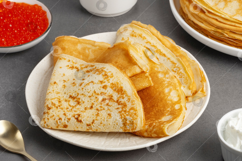 Скачать Свежеиспеченные блинчики со сметаной и красной икрой фотосток Ozero