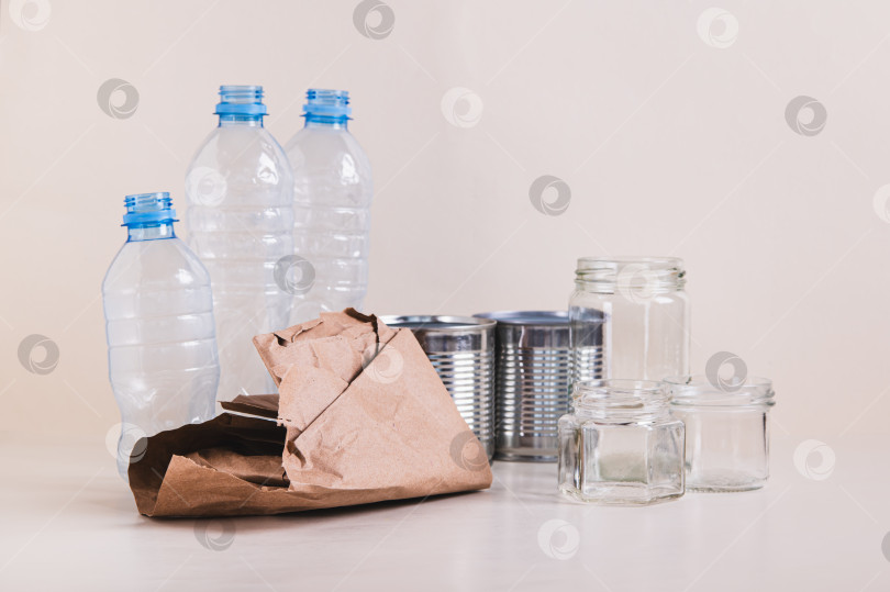 Скачать Бумага, стекло, металл и пластик для раздельного сбора отходов на столе фотосток Ozero