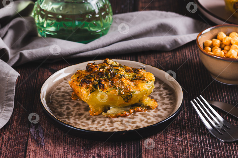 Скачать Хрустящий печеный картофель с сыром, чесноком и укропом на тарелке фотосток Ozero