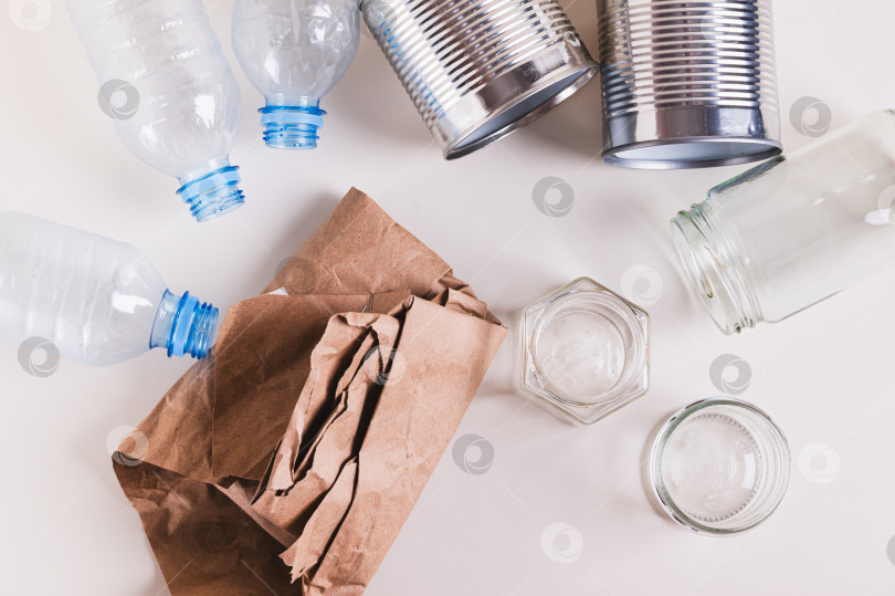 Скачать Бумага, стекло, металл и пластик для раздельного сбора отходов на столе, вид сверху фотосток Ozero