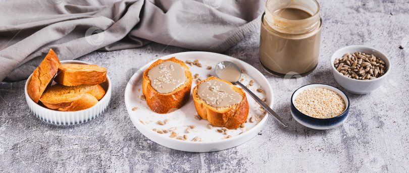 Скачать Урбеч из семян кунжута и подсолнечника на хлебе на тарелке веб-баннер фотосток Ozero