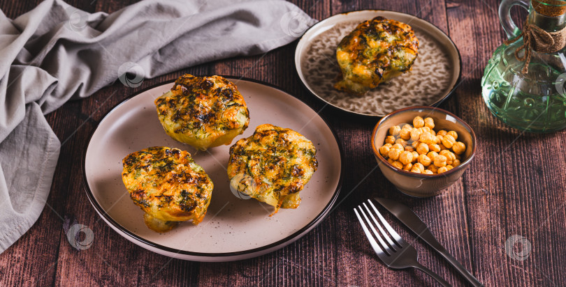 Скачать Половинки картофеля, запеченные с сыром, чесноком и зеленью на тарелке, на веб-баннере "Стол" фотосток Ozero