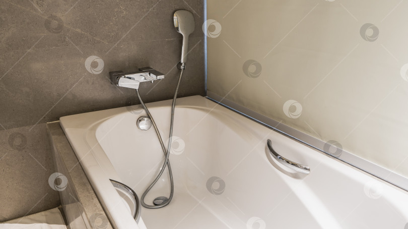 Скачать Белая прямоугольная акриловая ванна в углу ванной комнаты. фотосток Ozero