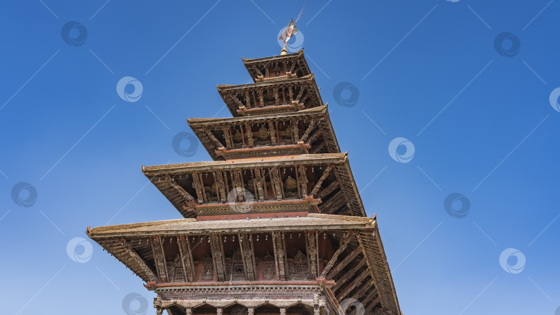 Скачать Многоярусная крыша пагоды на фоне ясного голубого неба фотосток Ozero