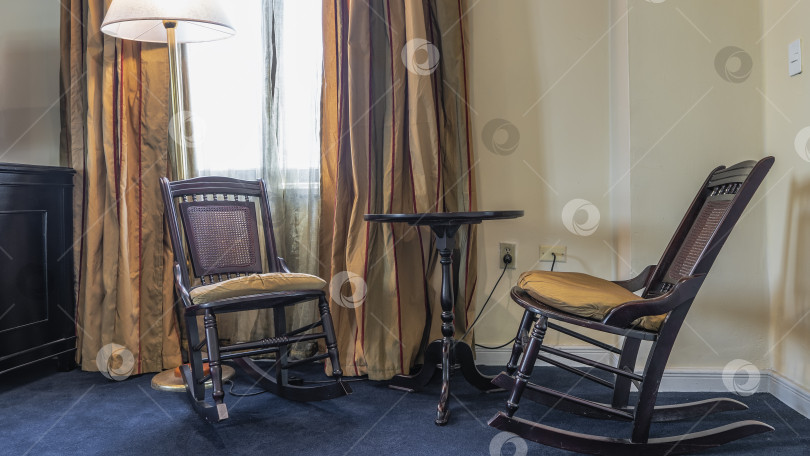 Скачать Детали интерьера в стиле ретро. Два деревянных кресла-качалки с подушками на сиденьях фотосток Ozero