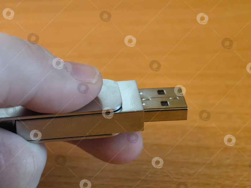 Скачать Компактная серебристая USB-флешка, зажатая в пальцах фотосток Ozero