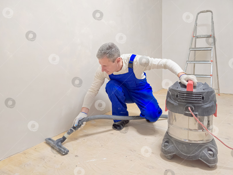 Скачать Мужчина моет пол пылесосом. фотосток Ozero