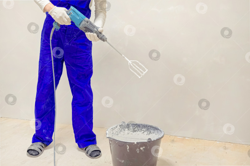 Скачать Крупным планом рабочий, замешивающий жидкий бетон фотосток Ozero