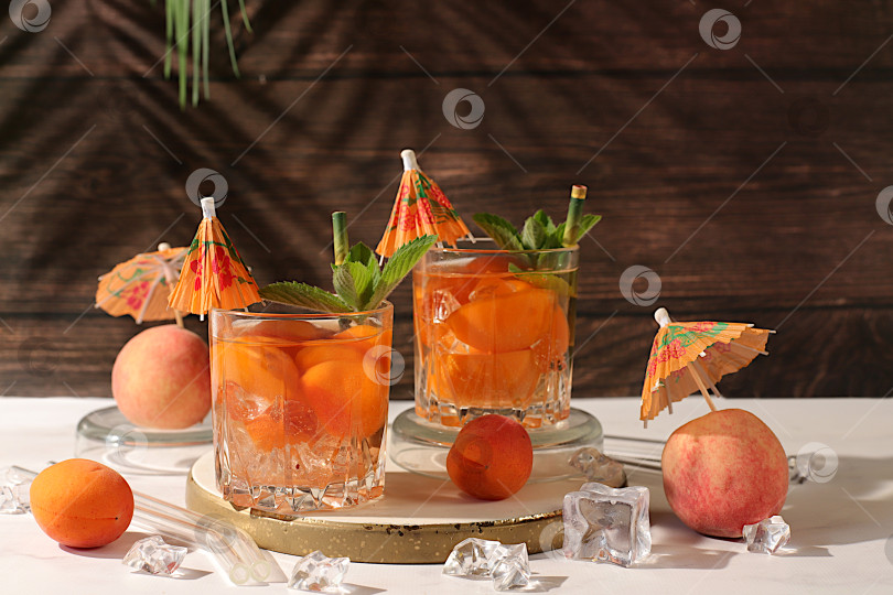 Скачать Рецепт освежающего летнего напитка. Холодный домашний лимонад, сок или коктейль с мятой, абрикосами, персиками и цитрусовыми, концепция детокс-диеты и похудения, ресторанное меню, избирательный подход фотосток Ozero