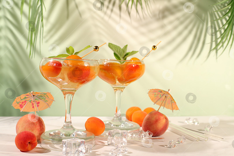 Скачать Алкогольный коктейль или пунш, ягоды персика, абрикоса и мяты на элегантном фоне, минималистичная концепция для бара и праздничной вечеринки, кафе, рекламный баннер, современный натюрморт с фруктами. фотосток Ozero