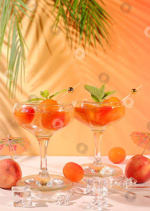Скачать Современный натюрморт с алкогольным коктейлем или пуншем, ягодами персика, абрикоса и мяты на элегантном фоне, минималистичная концепция для бара и праздничной вечеринки, кафе, рекламного баннера фотосток Ozero
