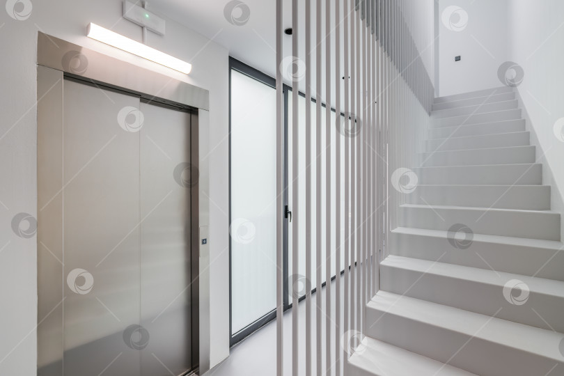 Скачать Современный стиль хай-тек в подъезде нового дома или офисного здания с лифтом, лестницей и панорамным окном. Концепция новых зданий с развитой современной структурой фотосток Ozero