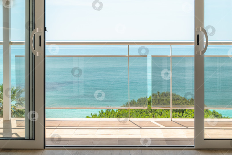 Скачать Захватывающий дух вид из гостиничного номера через панорамное окно с террасой на море в солнечный теплый летний день с голубым небом на роскошном курорте. Концепция отдыха после трудового года фотосток Ozero
