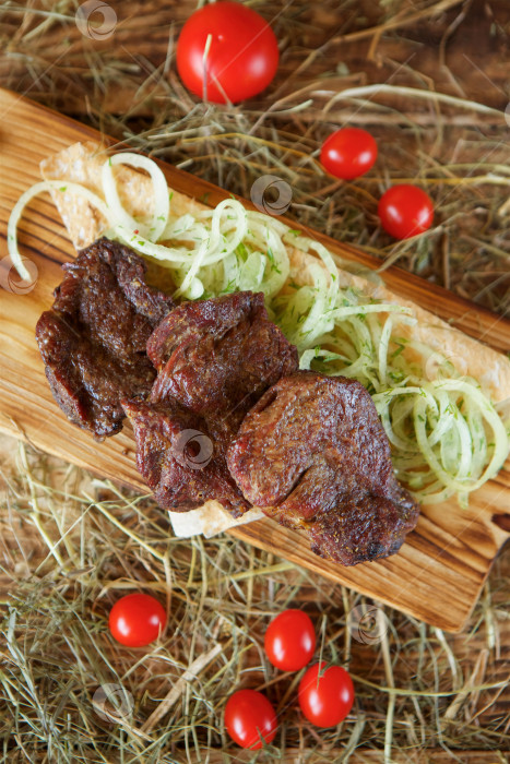 Скачать Приготовленные на гриле мясные шашлыки выложите на деревянную доску. Украсьте овощами и тонким хлебом. Приготовьте по рецептам шеф-повара. фотосток Ozero