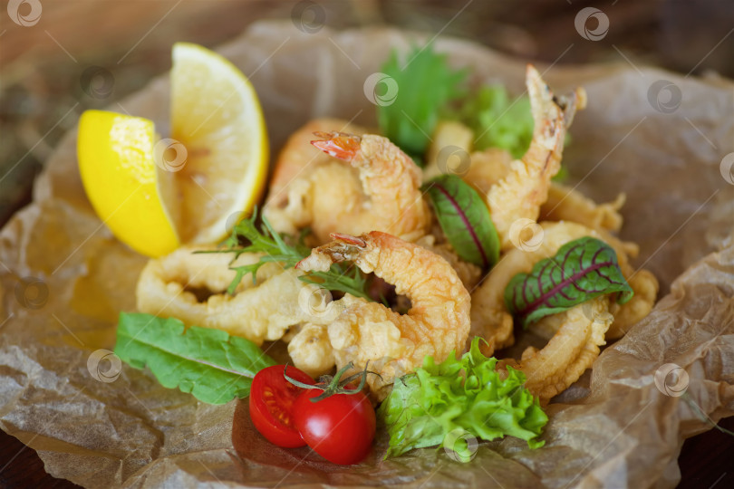 Скачать Креветки, кольца кальмаров и другие морепродукты, обжаренные во фритюре в кляре. фотосток Ozero