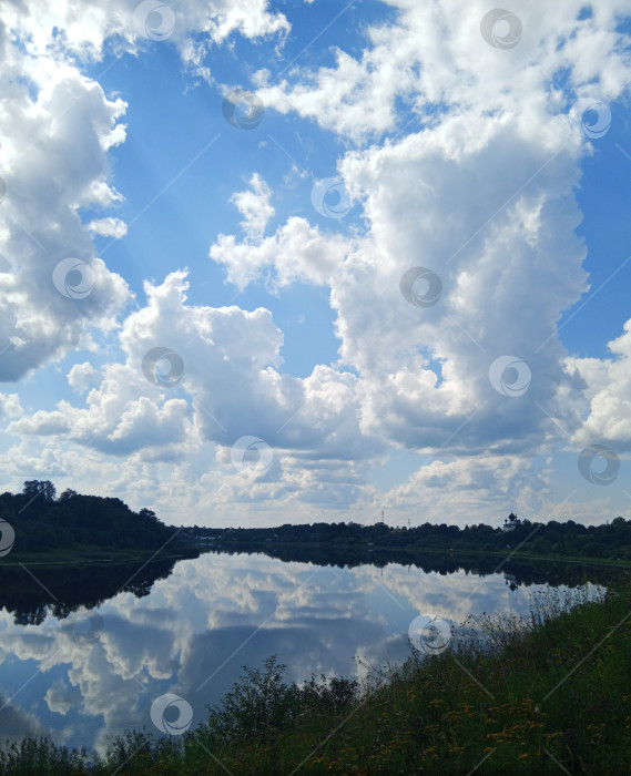 Скачать Зеркальное отражение пышных кучевых облаков в реке Волхов фотосток Ozero