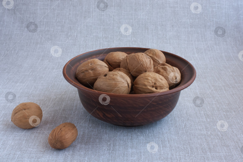 Скачать грецкие орехи в глиняной миске и на льняной скатерти фотосток Ozero
