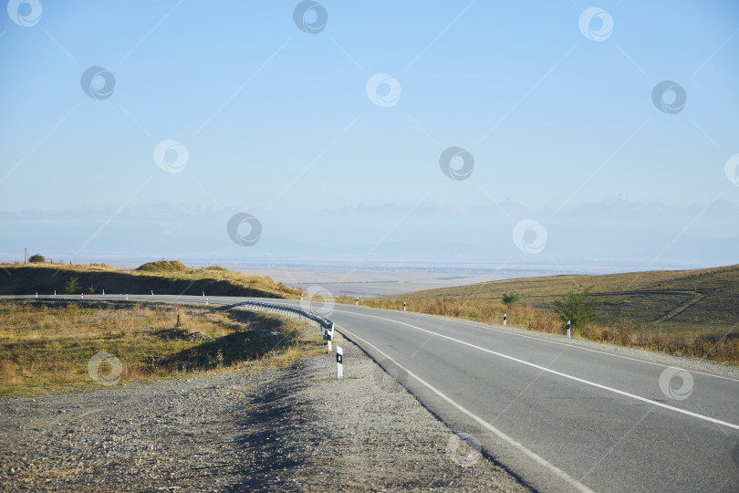Скачать Загородное шоссе осенью. Пустынные дороги среди холмов фотосток Ozero