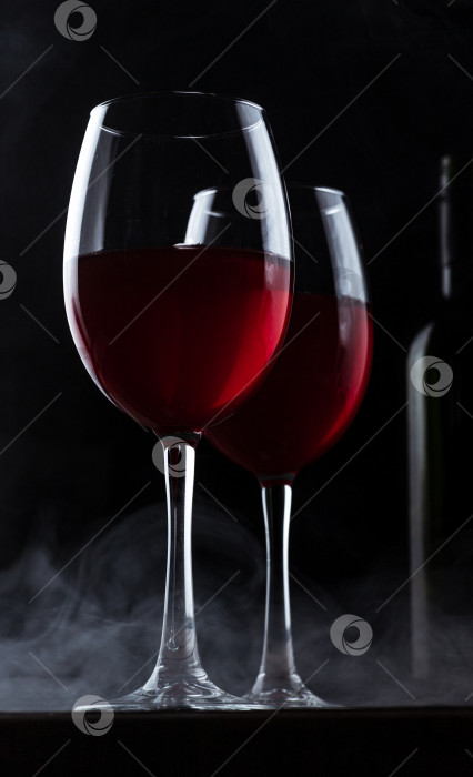 Скачать Бокалы с красным вином и силуэтом бутылки фотосток Ozero