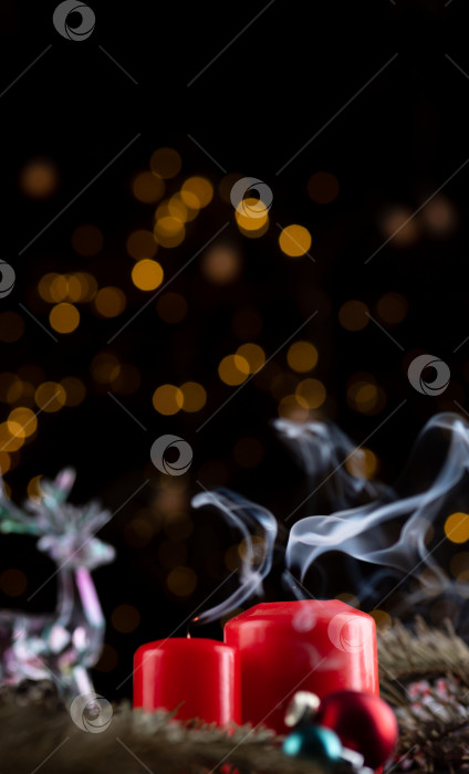 Скачать Две свежесушенные красные свечи на новогоднем столе. от фитилей идет белый дым фотосток Ozero