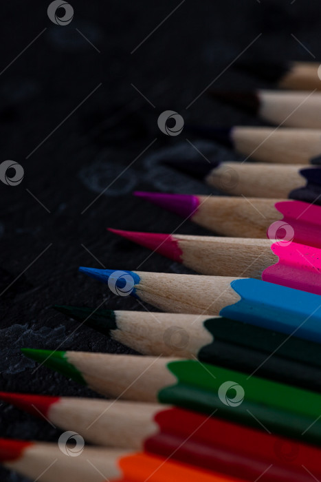 Скачать Цветные карандаши лежат на темном фоне фотосток Ozero
