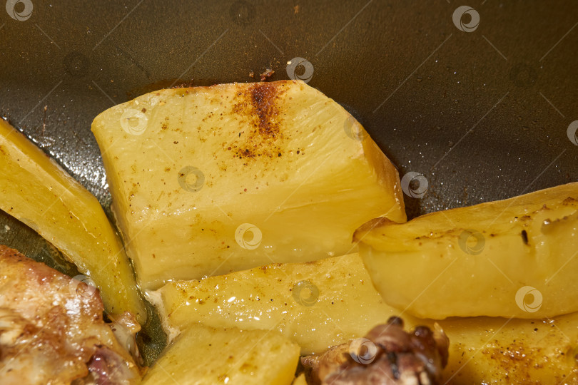 Скачать Запеченные в духовке кусочки курицы с ломтиками картофеля и смесью приправ. фотосток Ozero