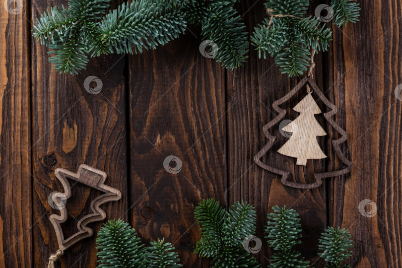 Скачать Новогодний фон. Деревянные доски, ветви нобилиса и деревянные украшения в виде рождественских елок фотосток Ozero