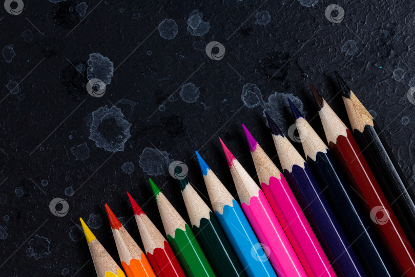 Скачать Цветные карандаши лежат на темном фоне фотосток Ozero
