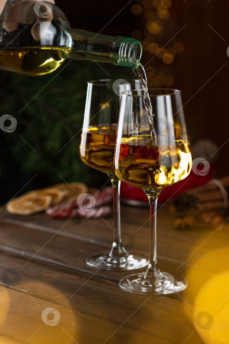 Скачать Белое вино разливают по бокалам из бутылки фотосток Ozero