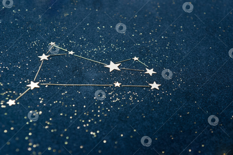 Скачать Знак зодиака Овен на звездном небе крупным планом. Аппликация из звездного конфетти и блестящего черного картона на тему астрологии и гороскопа. фотосток Ozero