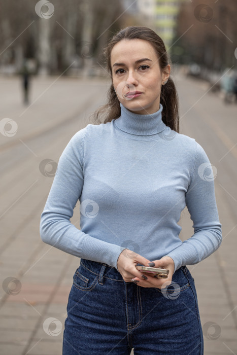 Скачать Уличный портрет красивой молодой женщины в синих джинсах фотосток Ozero