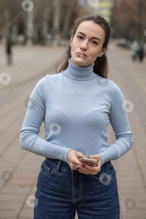 Скачать Уличный портрет красивой молодой женщины в синих джинсах фотосток Ozero
