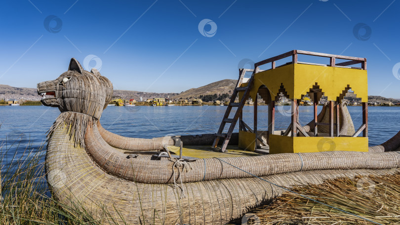 Скачать Традиционная тростниковая лодка Balsa de totora пришвартована у побережья плавучего острова Урос. фотосток Ozero