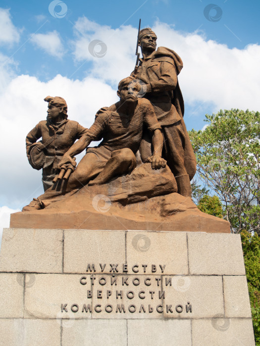 Скачать СЕВАСТОПОЛЬ, РОССИЯ - ИЮЛЬ, 15, 2015: Памятник героям-комсомольцам в Севастополе: бронзовая композиция из трёх фигур — солдат с винтовкой, раненый боец и девушка-санитарка. На постаменте надпись: «Мужеству, стойкости, верности комсомольской». фотосток Ozero