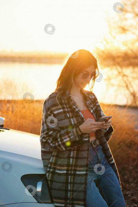 Скачать Женщина рядом с автомобилем использует карту мобильного приложения фотосток Ozero