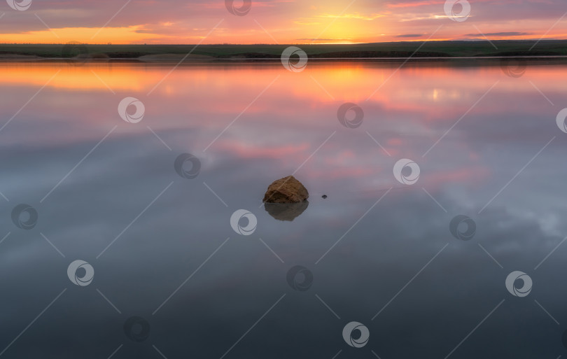 Скачать камень, покрытый кристаллами соли, лежащий посреди соленого озера Эльтон на фоне восходящего солнца фотосток Ozero