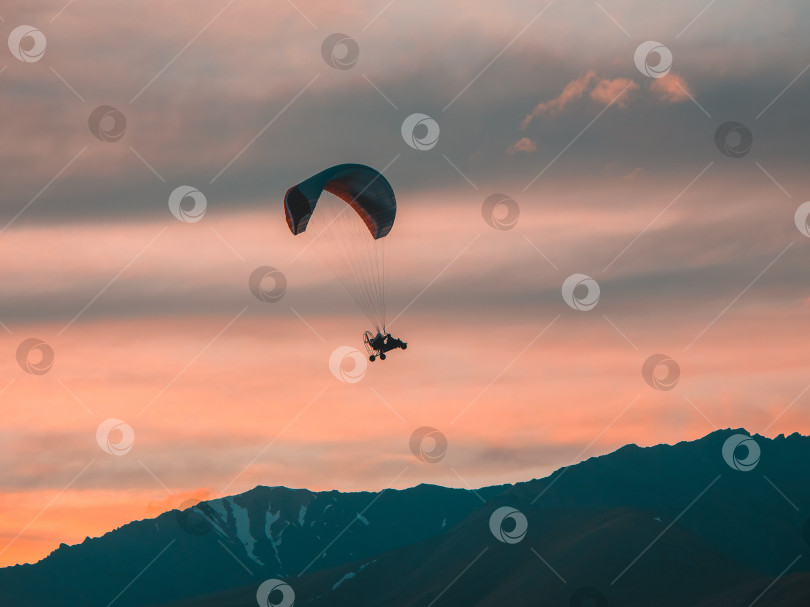 Скачать Экстремальные виды спорта. Приводимый в действие парашют над горами на закате. фотосток Ozero