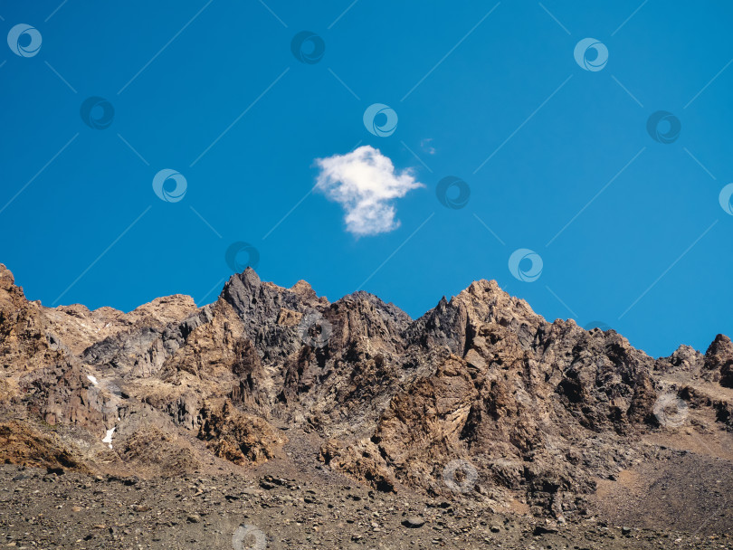 Скачать Маленькое белое облачко над скалистым горным хребтом. Горный природный минималистичный фон. фотосток Ozero