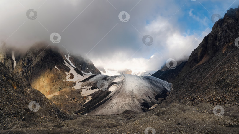 Скачать Панорамный вид на Большой ледник Актру, расположенный высоко в горах, покрытый снегом и льдом. Драматический зимний пейзаж Алтая. фотосток Ozero