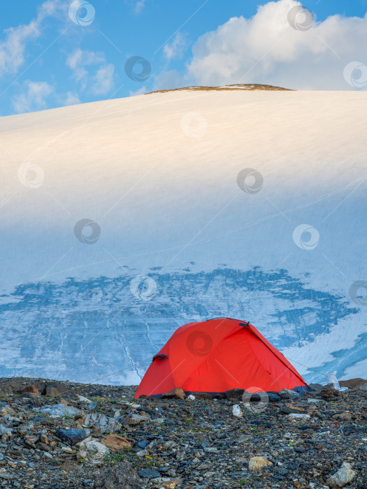 Скачать Утренний вид оранжевой укрепленной палатки на фоне ледника на высокогорном плато. фотосток Ozero