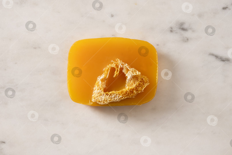 Скачать Кусочек мыла ручной работы с куркумой на белом мраморном фоне. фотосток Ozero