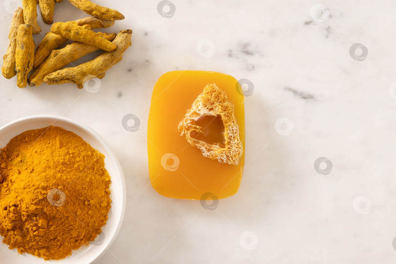 Скачать Кусочек мыла ручной работы с куркумой на белом мраморном фоне. фотосток Ozero