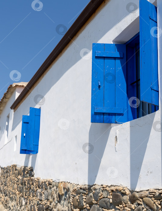 Скачать типичная средиземноморская архитектура, белый фасад дома и синие деревянные ставни на окнах фотосток Ozero