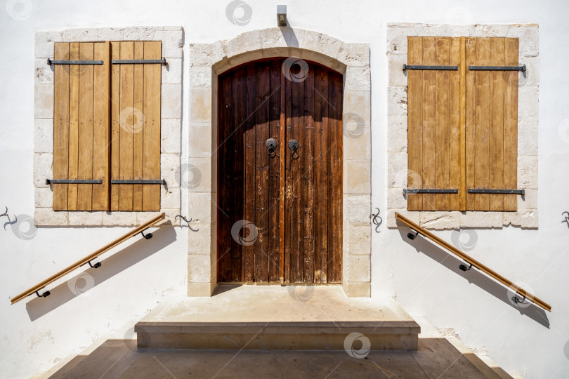 Скачать Вход в старое здание с закрытой деревянной дверью и деревянными ставнями на окнах фотосток Ozero