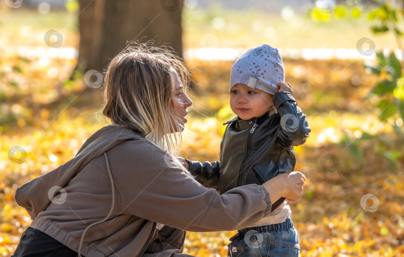 Скачать Счастливые мать и ребенок играют в осеннем парке фотосток Ozero