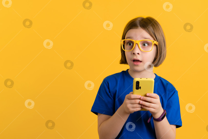 Скачать Ребенок со смартфоном в студии фотосток Ozero