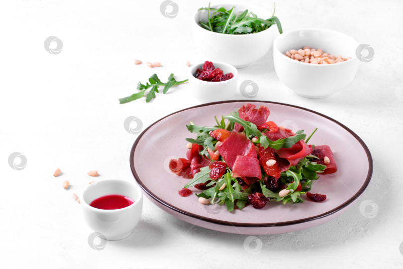 Скачать Салат с копченой утиной грудкой, рукколой, сушеной клюквой, кедровыми орешками и заправкой из сока красного апельсина фотосток Ozero