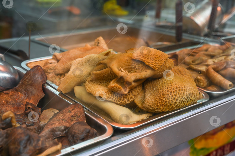 Скачать Традиционные кантонские тушеные говяжьи субпродукты с рубцом в виде сот в местном уличном киоске на знаменитой пешеходной улице Руа-ду-Кунья в Тайпа-Макао. фотосток Ozero