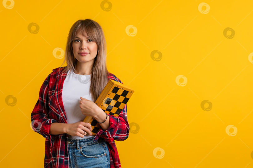 Скачать Молодая женщина держит шахматную доску фотосток Ozero