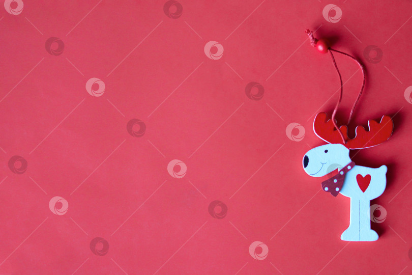 Скачать Новогодний и рождественский плоский красный фон с орнаментом в виде деревянного оленя и небольшим пространством для текста фотосток Ozero
